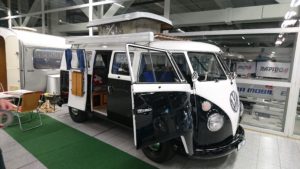 Schwarz-weisser VW Bulli mit geöffneten Türen